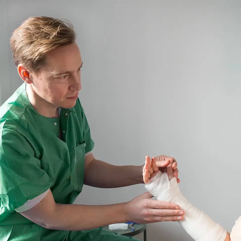 Orthopedist examining a patient's fractured forearm